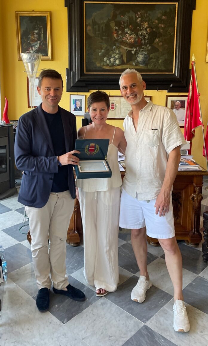Da dieci anni, ogni estate, Patricia Cirucci, torna a Sorrento incantata "dalla bellezza del paesaggio, dall’accoglienza, dalla convivialità delle persone, dal cibo ineguagliabile". Durante il resto dell'anno, nei momenti liberi, cucina per gli amici ricette di piatti tipici sorrentini, e decanta loro le tante attrattive della terra delle sirene. Quest'anno l'occasione è stata speciale. Lei, avvocato, residente in California, negli Stati Uniti, ha deciso di sposare Dustin Coleman, anche lui californiano, ingegnere e docente universitario, proprio nella cittadina costiera. Le nozze si sono celebrate ieri in una nota struttura della zona. Per premiare la "fedeltà" di Patricia a questa terra, il sindaco di Sorrento, Massimo Coppola, ha voluto ricevere i novelli sposi al Palazzo Municipale. Una visita, questa, che giunge a coronamento di una settimana di festeggiamenti conclusa proprio questa mattina, con un saluto ad amici e parenti, tutti provenienti dagli Stati Uniti. Dopo avere ringraziato la coppia per il loro passione per Sorrento, il primo cittadino ha voluto donare loro una scatola intarsiata, prodotta da maestri artigiani locali, come regalo per il loro giorno più bello e come invito a tornare anche il prossimo anno.