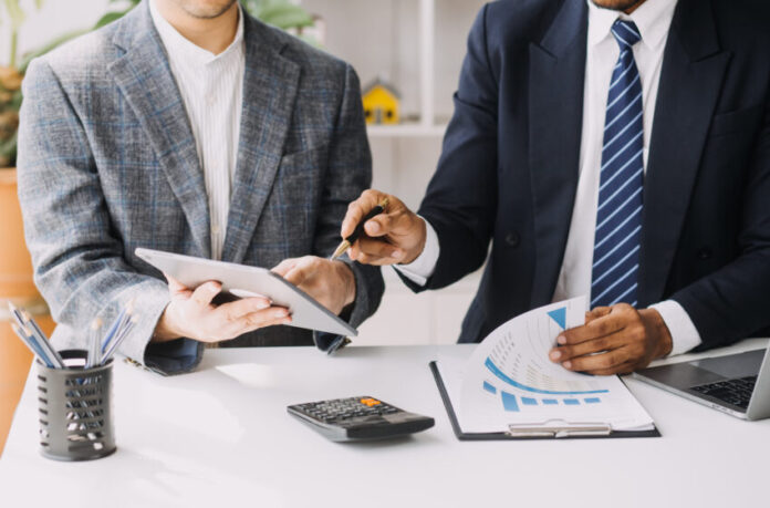 Financial analysts analyze business financial reports on a digital tablet planning investment project during a discussion at a meeting of corporate showing the results of their successful teamwork.