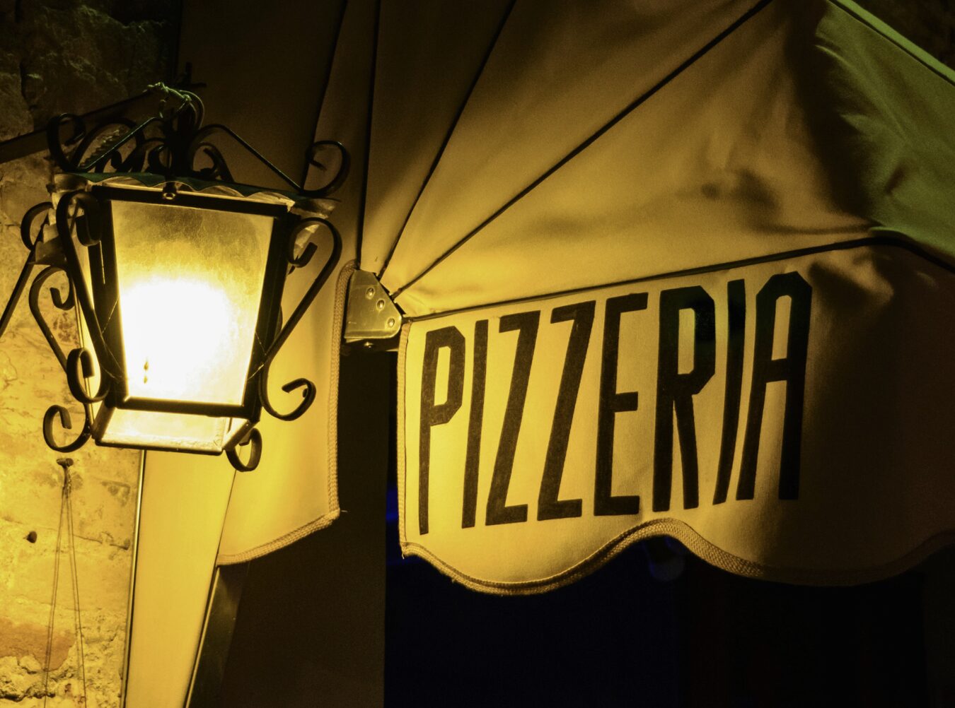 Insegna di una pizzeria illuminata di notte