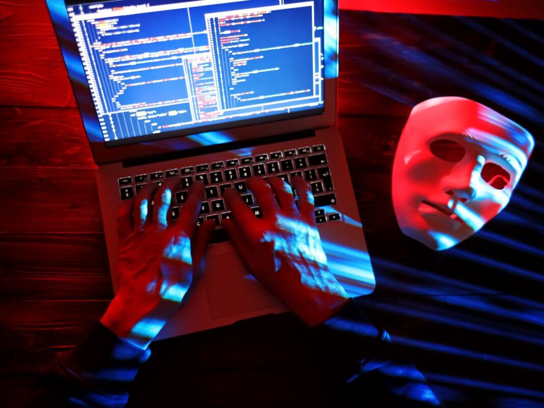 Un cybercriminale con in mano il pc